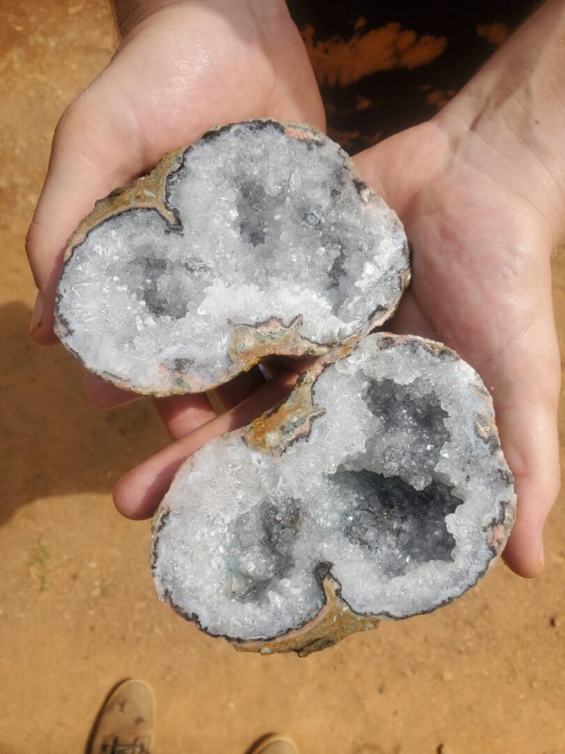 A person holding two pieces of rock in their hands.