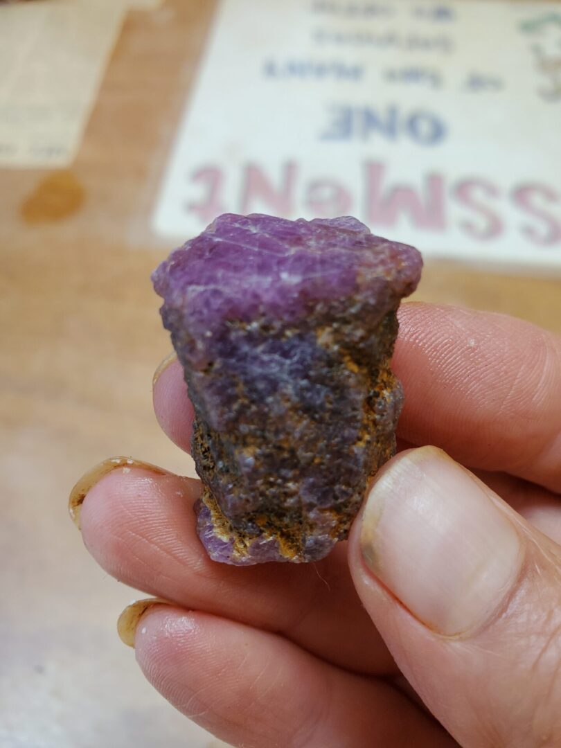A person holding onto a piece of purple rock