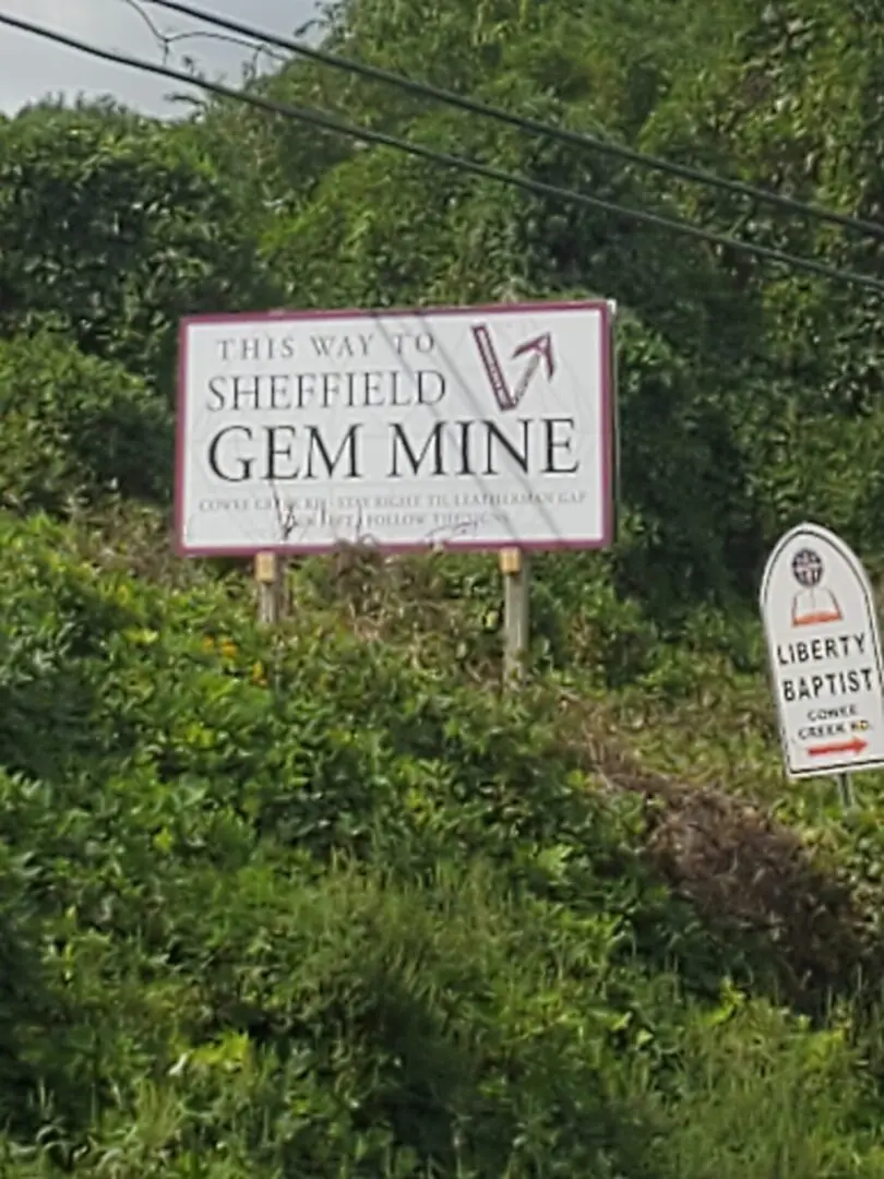 A sign that says " this way to sheffield gem mine ".