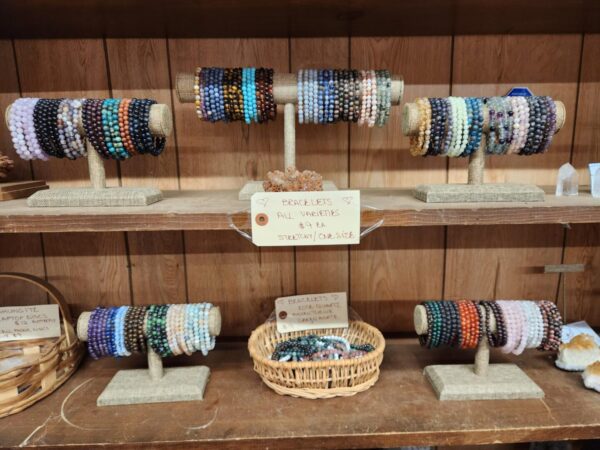 A display of bracelets on wooden shelves.