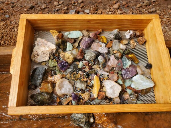 A wooden box filled with rocks and stones.