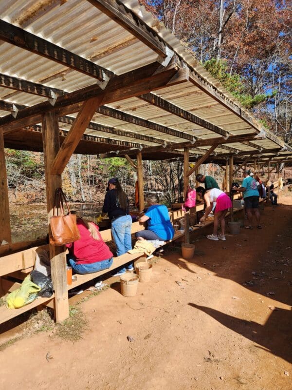 A group of people sitting on benches under an awning.