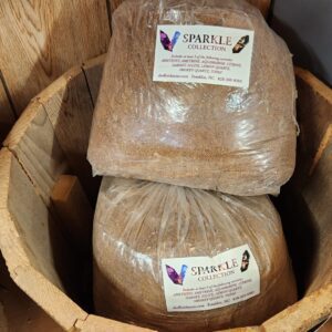 A wooden barrel with two bags of grains in it.