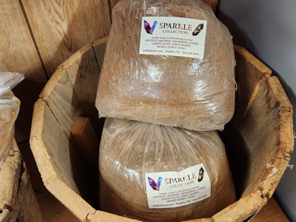 A wooden barrel with two bags of grains in it.