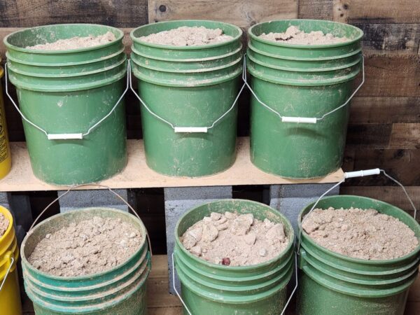 A couple of green buckets filled with dirt.