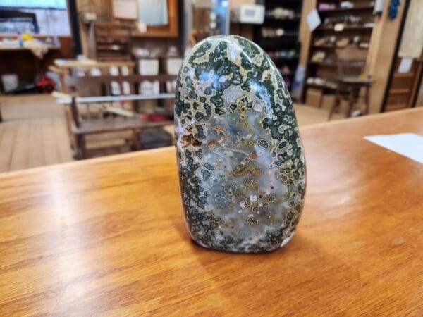 A green stone sitting on top of a wooden table.