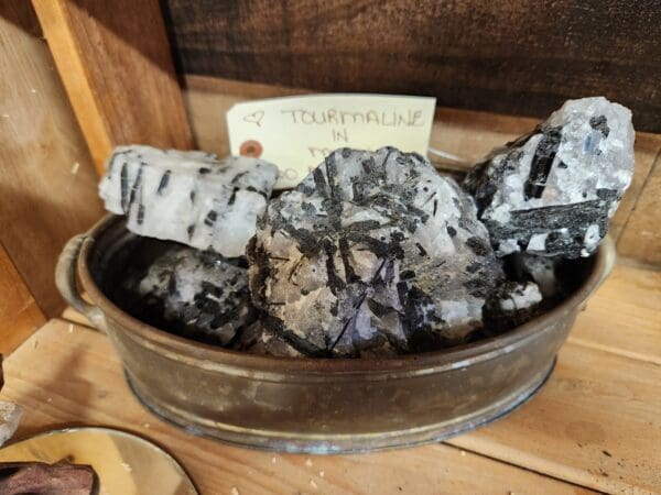 A bowl of black and white rocks on top of a table.