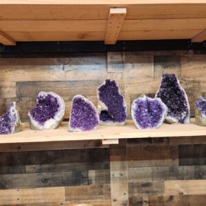 A shelf with many different types of purple rocks.