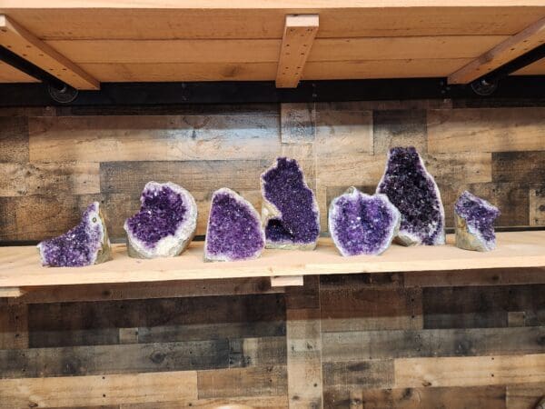 A shelf with many different types of purple rocks.