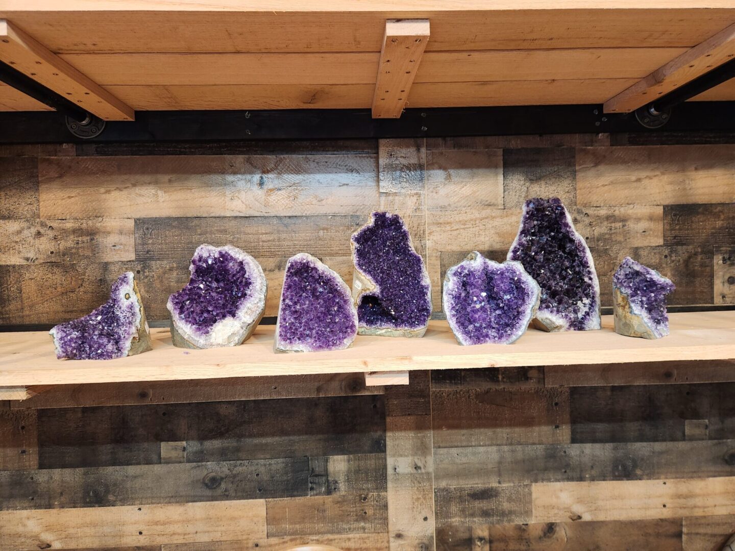 A shelf with many different types of purple rocks.