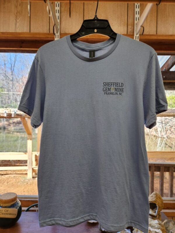 A gray t-shirt hanging on a rack.