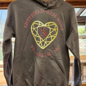A brown hoodie with a gold heart on it.