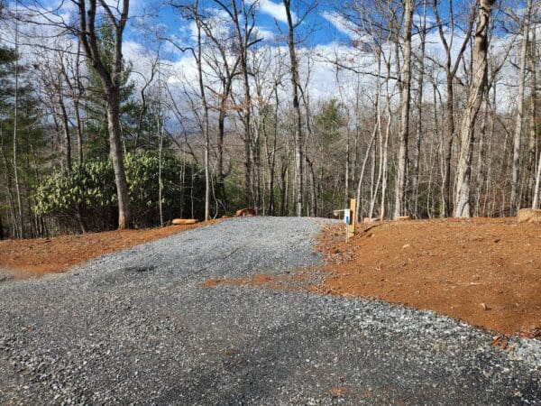 A gravel road in the middle of a wooded area.