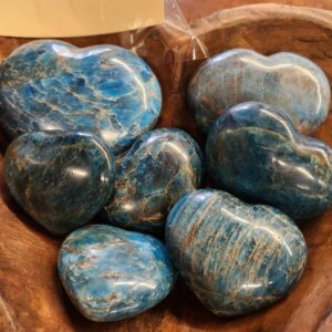 A wooden bowl filled with blue stones.