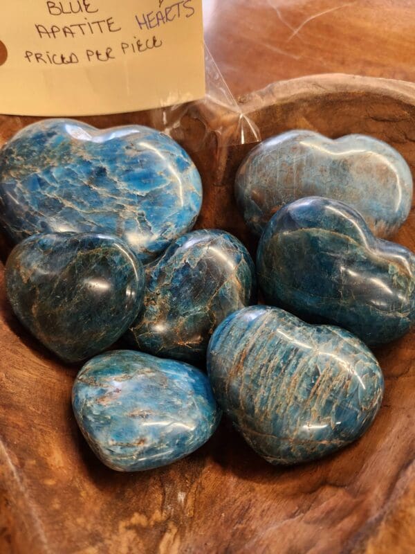 A wooden bowl filled with blue stones.