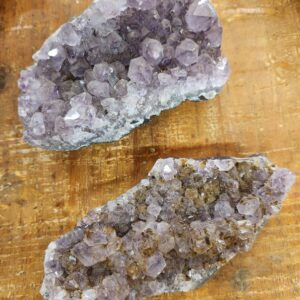 Two pieces of amethyst are sitting on a table.