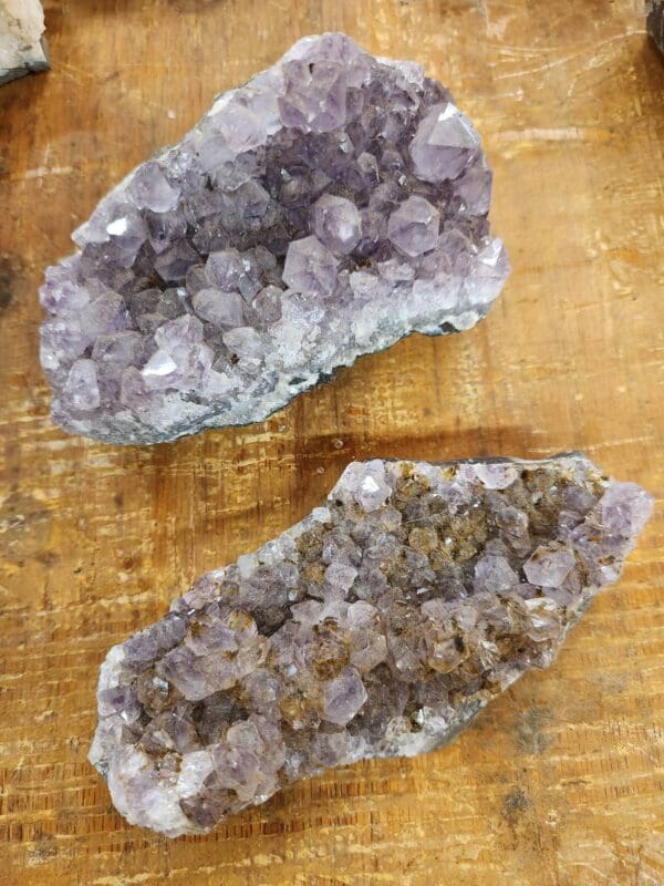 Two pieces of amethyst are sitting on a table.