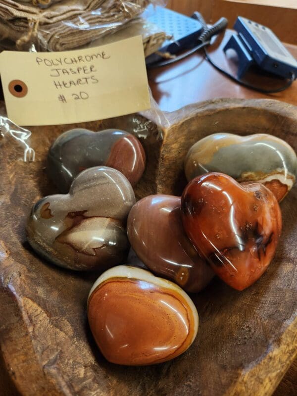 A wooden bowl with some different colored hearts