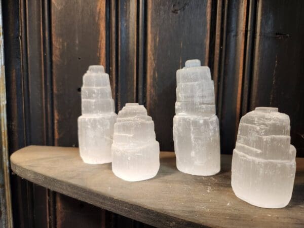 A wooden shelf with some white glass containers