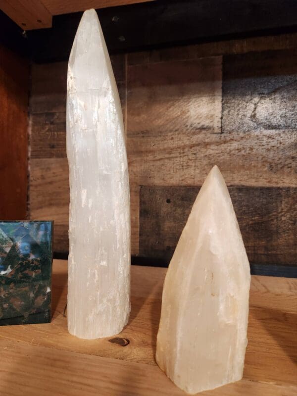 Two large selenite obelisks on a table.