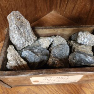 A wooden box filled with rocks on top of the floor.