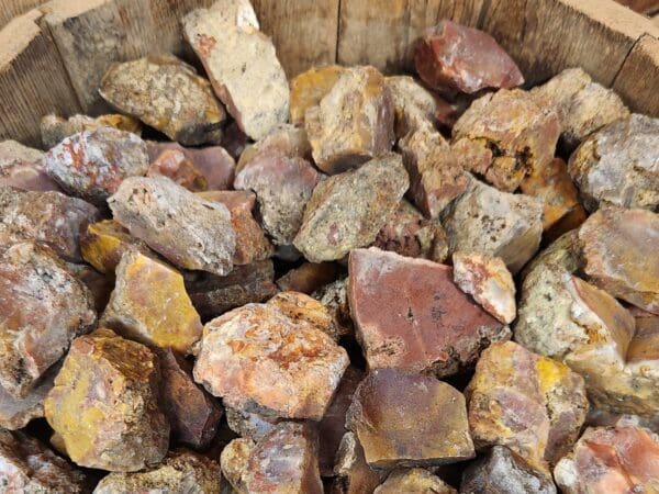 A wooden bowl filled with rocks of various colors.