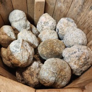 A wooden basket filled with lots of rocks.