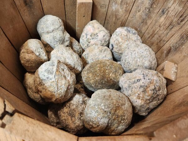 A wooden basket filled with lots of rocks.