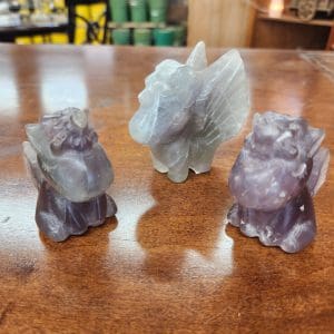 Three different colored animals sitting on a table.