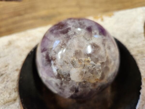 A close up of a crystal ball on top of a black plate.