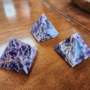 Three purple and white stones on a table.