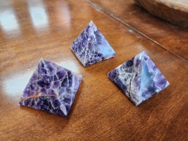 Three purple and white stones on a table.